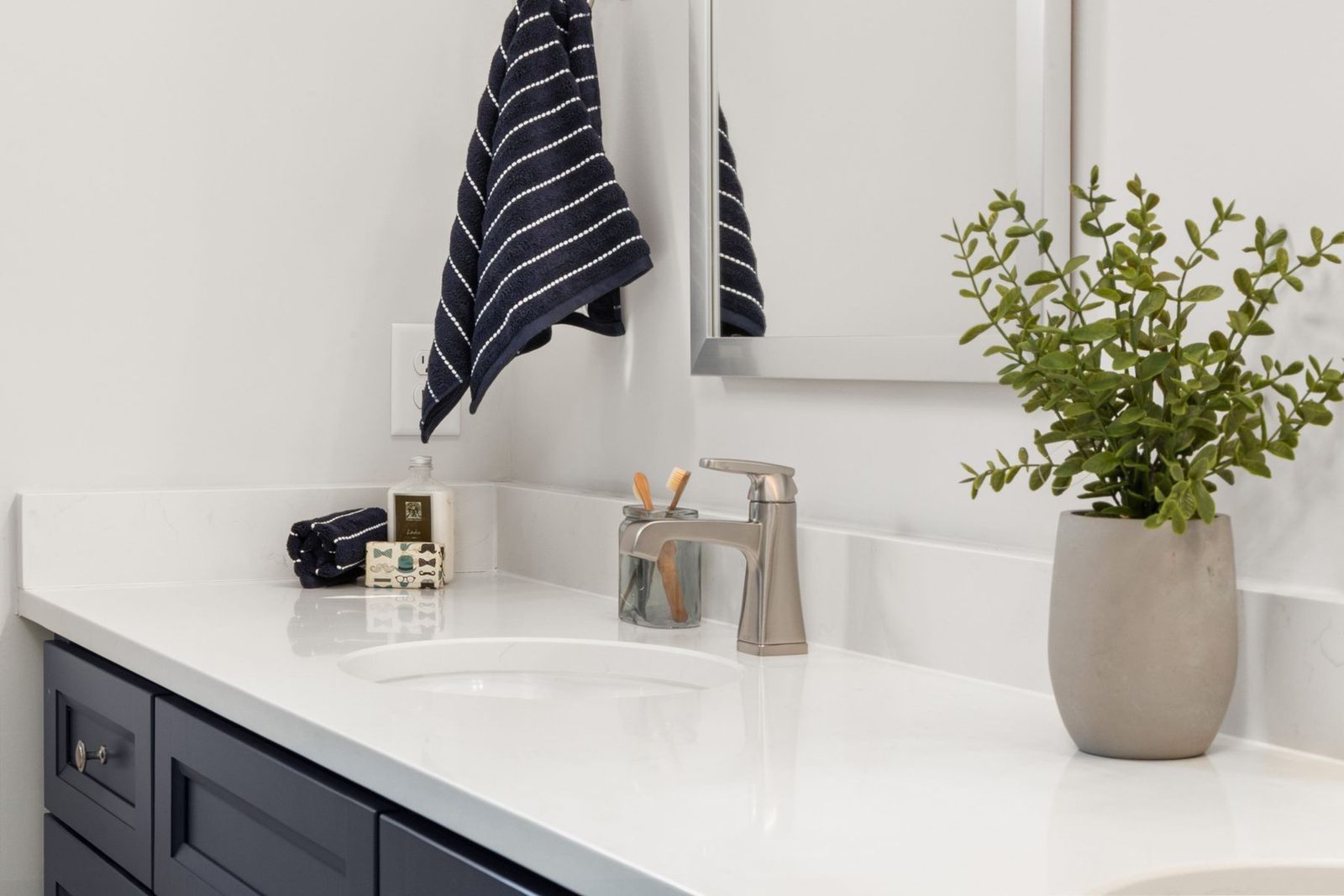 Bathroom vanity with potted plant and striped towel