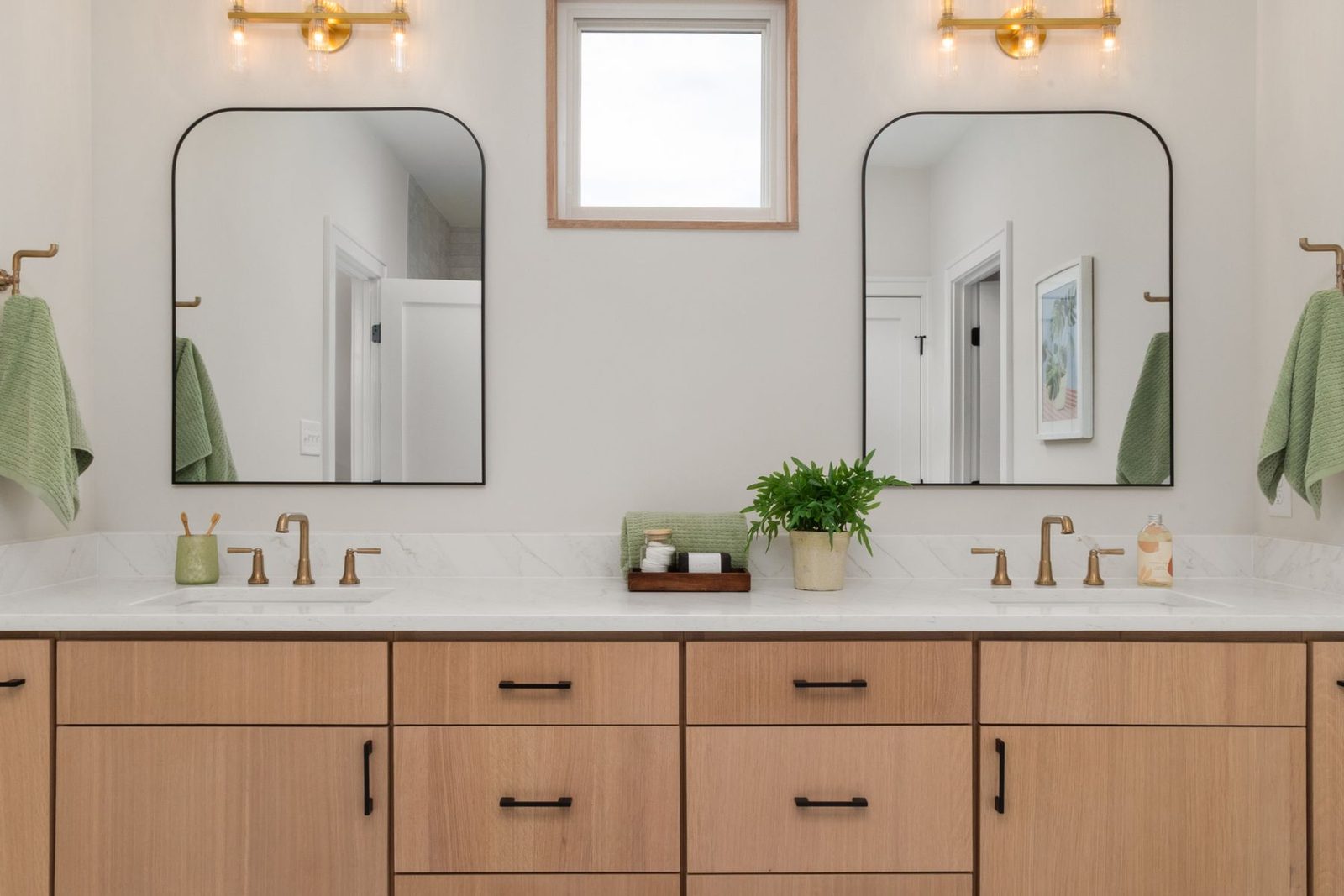 Bathroom with double sinks and mirrors over a wood vanity