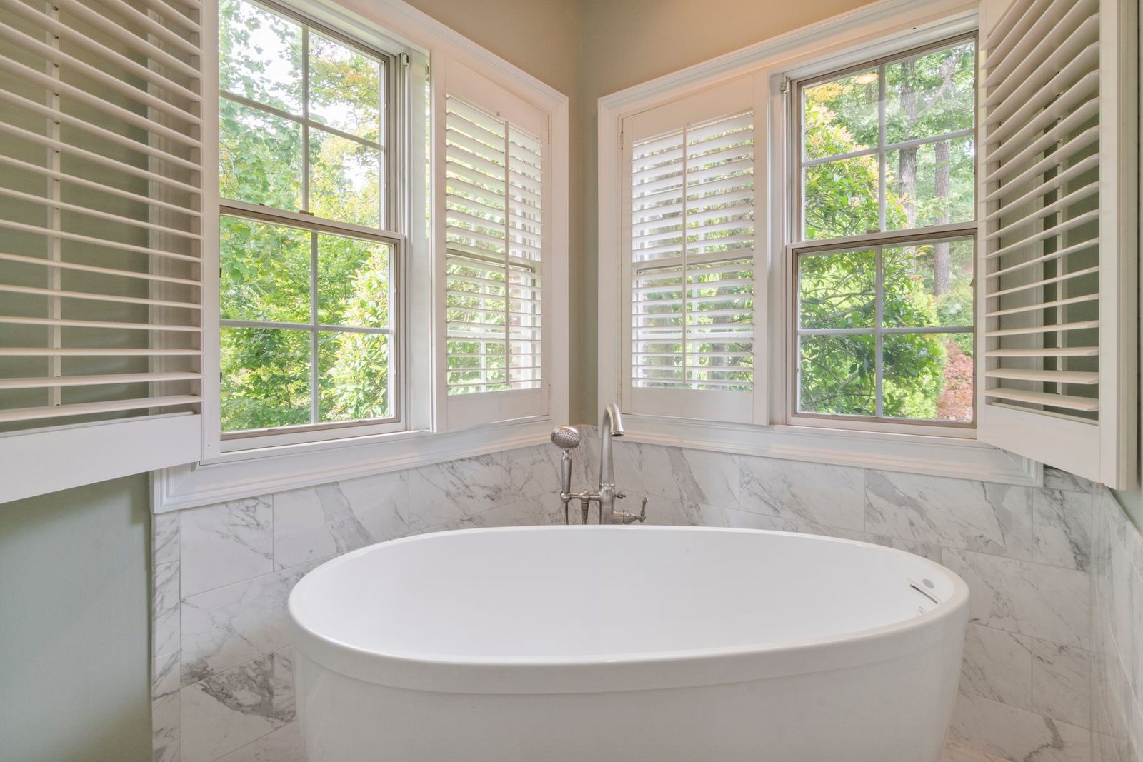Bathroom with freestanding tub and shuttered windows