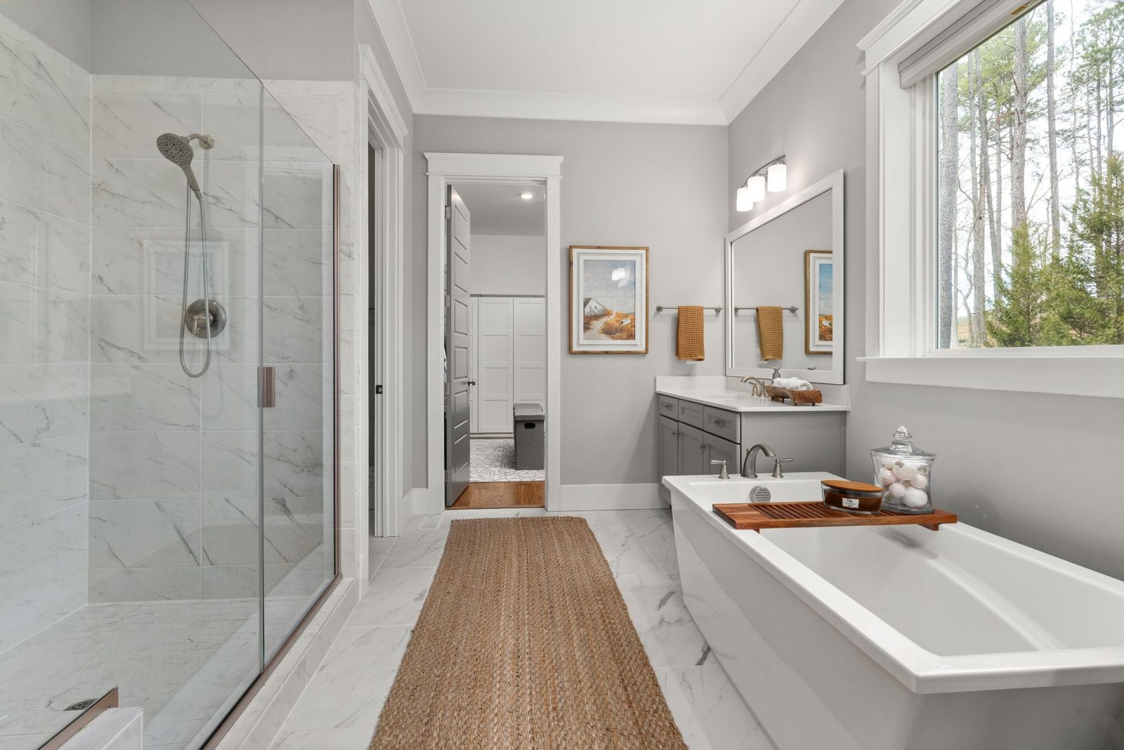 Bathroom with freestanding tub, glass shower and large window