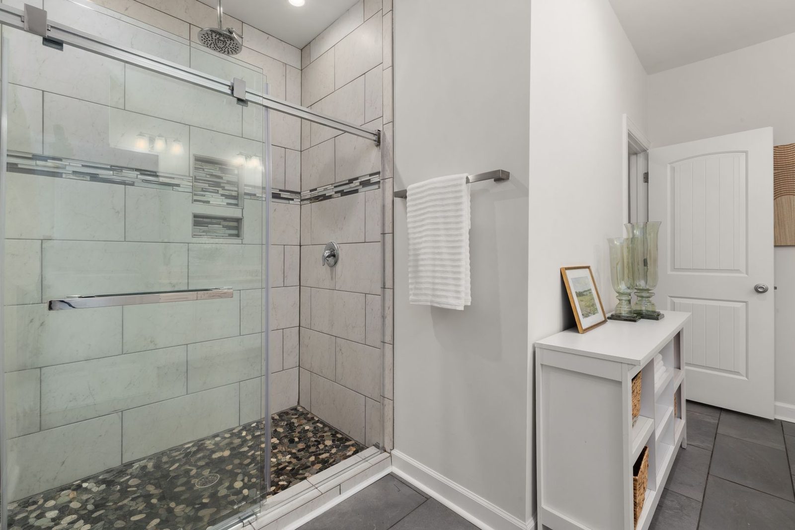 Bathroom with glass shower enclosure and stone tile floor