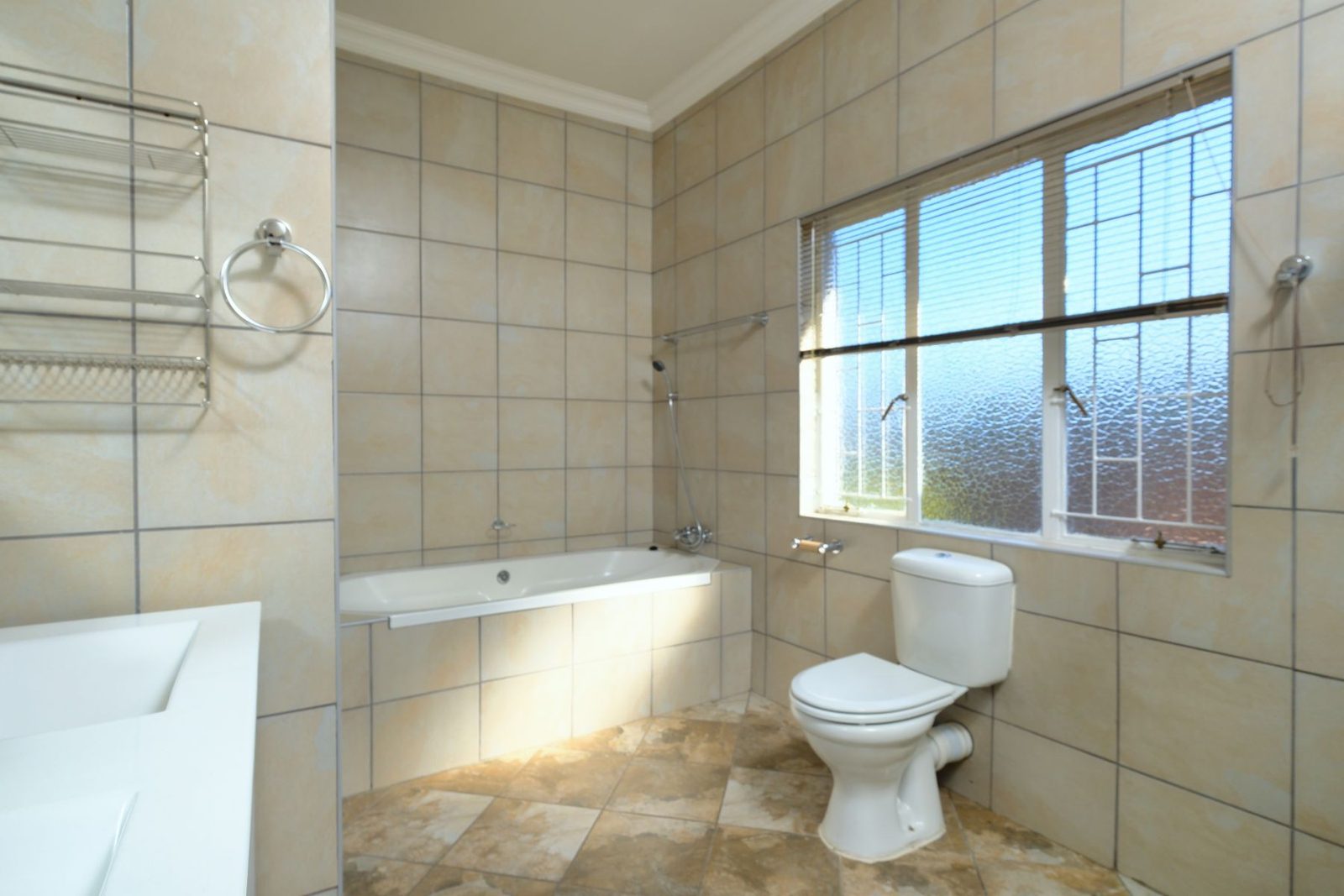 Bathroom with tiled walls, bathtub and window