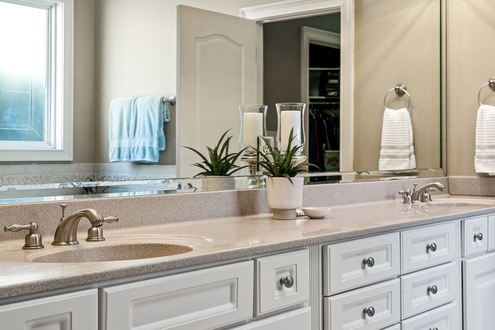 Bathroom with white cabinets, large mirror and brushed nickel faucets – gallery