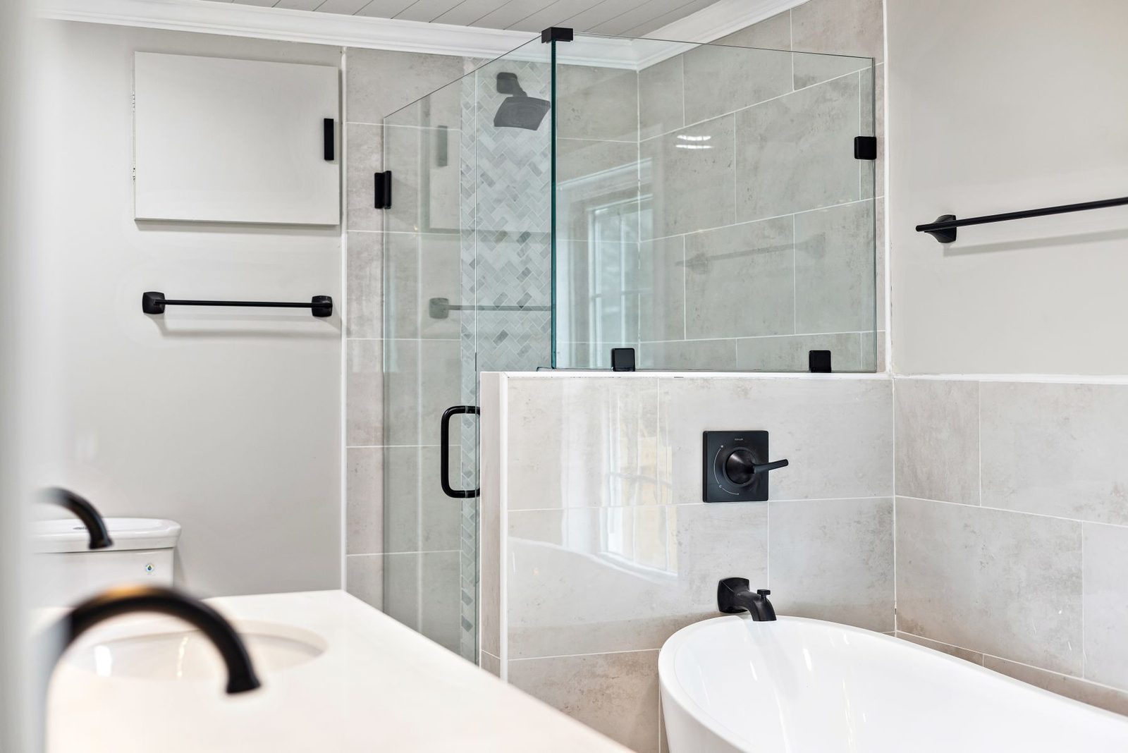 Bathroom with white tile, glass shower and bathtub – walk-in showers