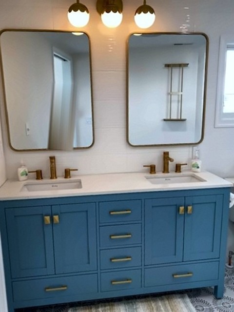 Blue double vanity with brass hardware, round-corner mirrors and globe light