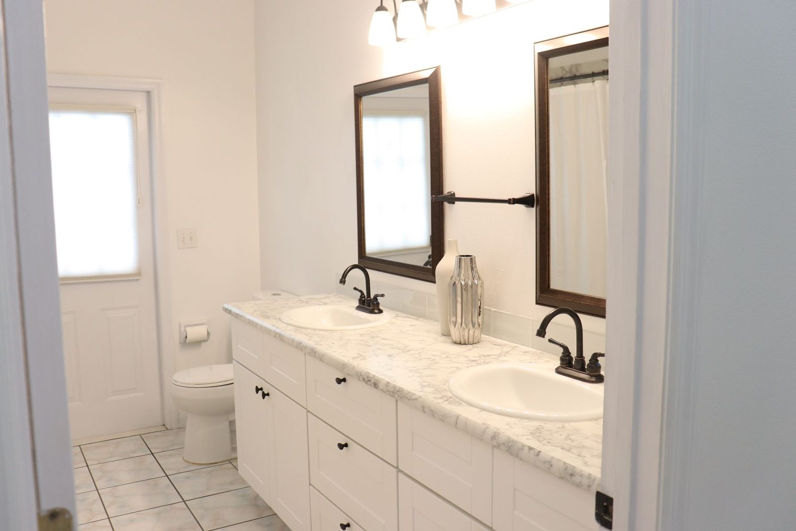 Bright bathroom with white vanity, mirrors and glass shower – walk-in showers