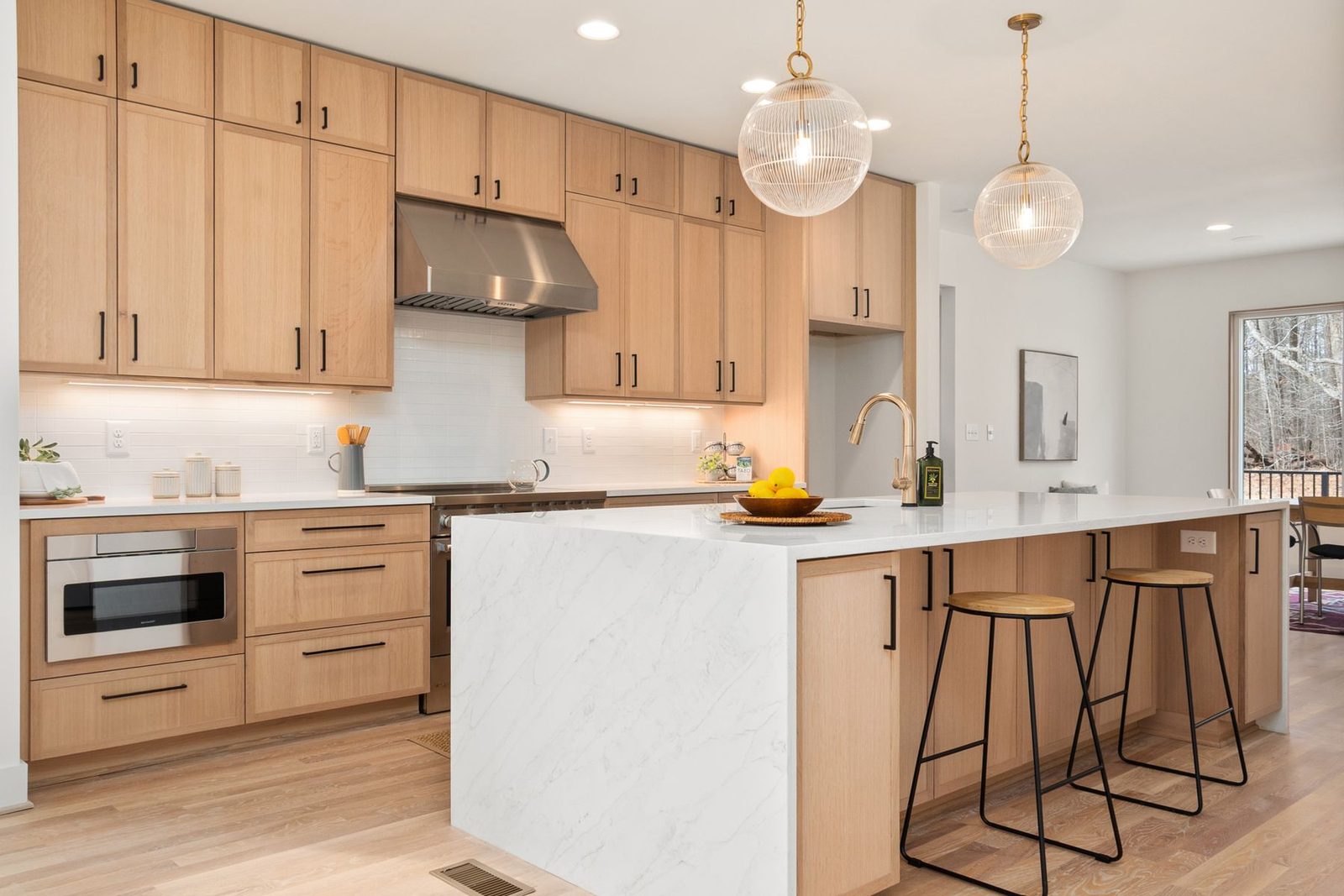 Bright kitchen with wood cabinets, marble island and pendant lights – Northfield NJ remodeling