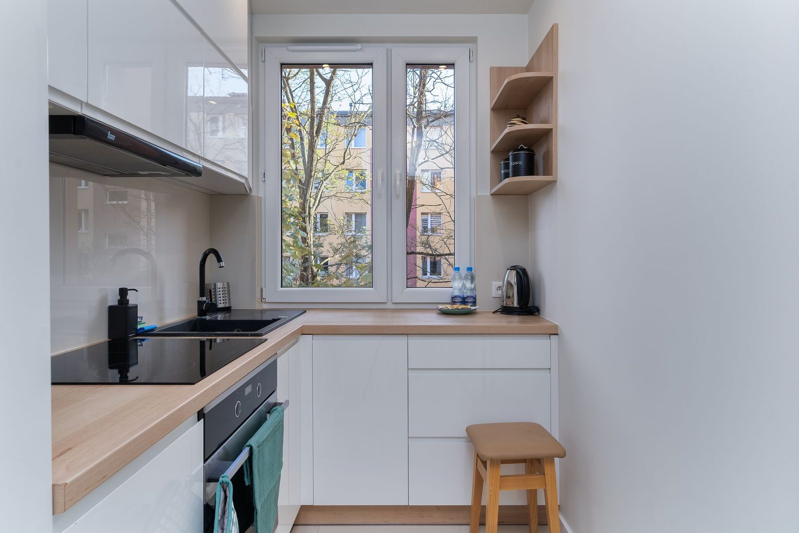 Compact modern kitchen with white cabinets and natural light – remodeling service area