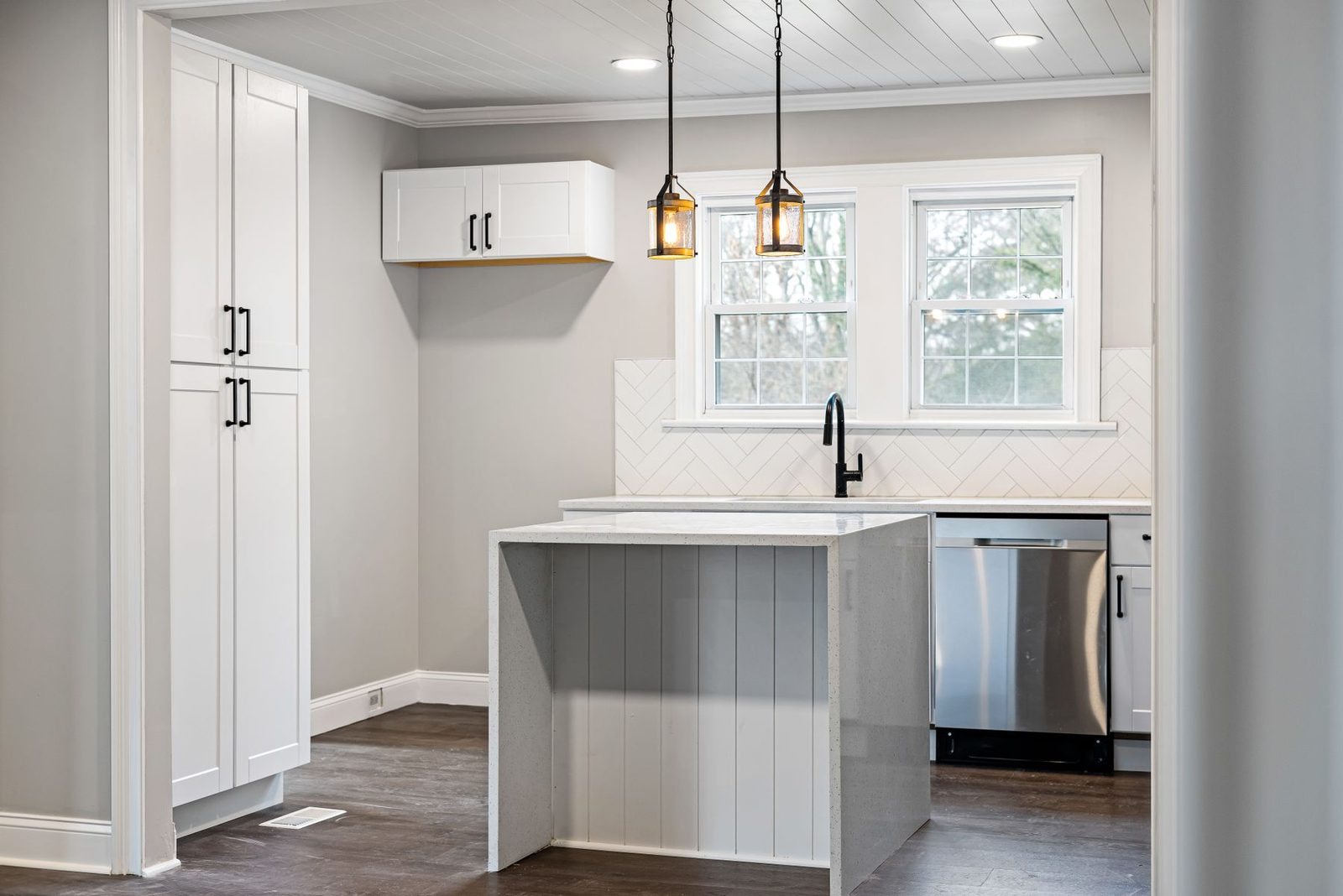 Contemporary kitchen with white cabinets and island lighting – gallery
