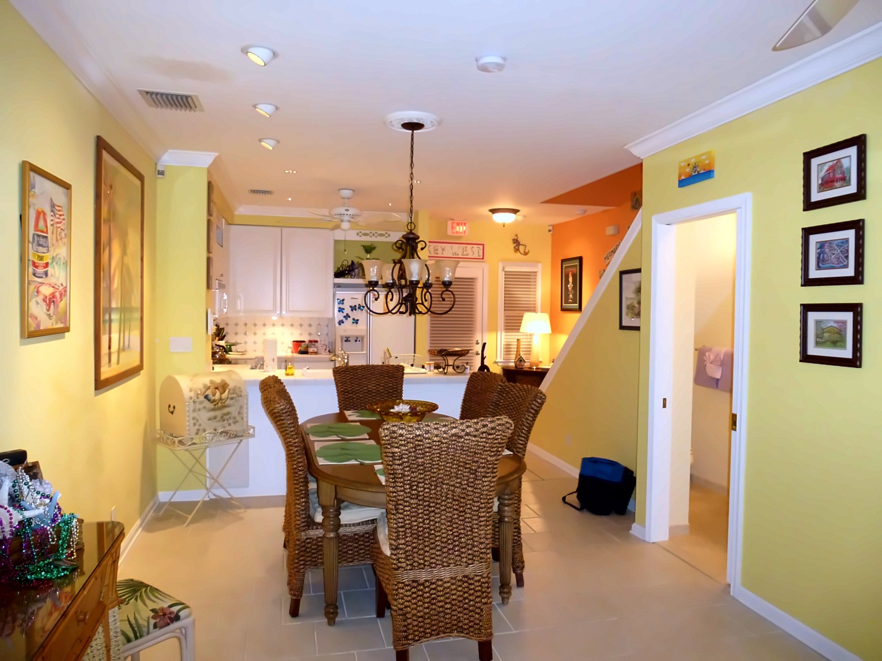 Kitchen and dining area with woven chairs and white cabinets