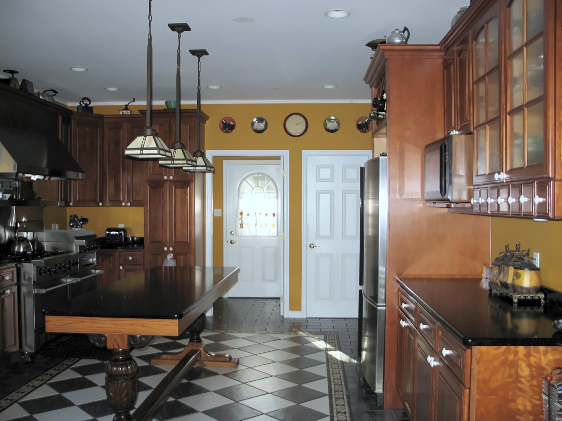 Kitchen with island, pendant lights and checkered tile floor