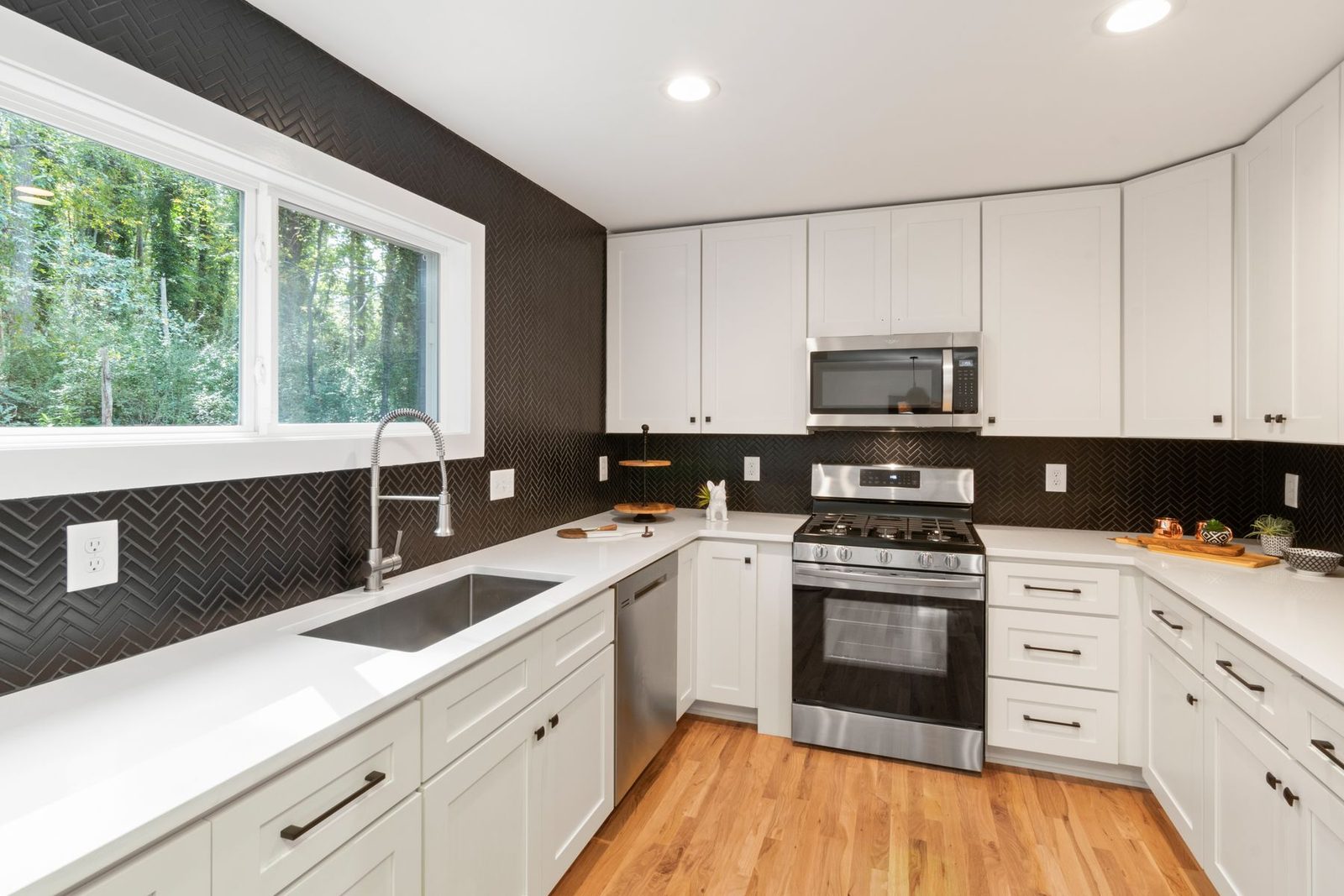 Kitchen with white cabinets, stainless appliances and wood floor