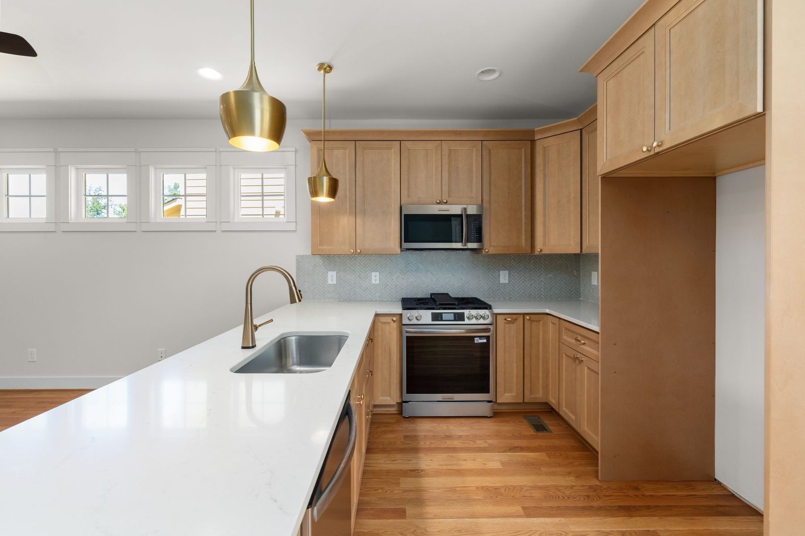 Kitchen with wood and white cabinets, stainless appliances and pendant lights – kitchen remodeling Ocean City