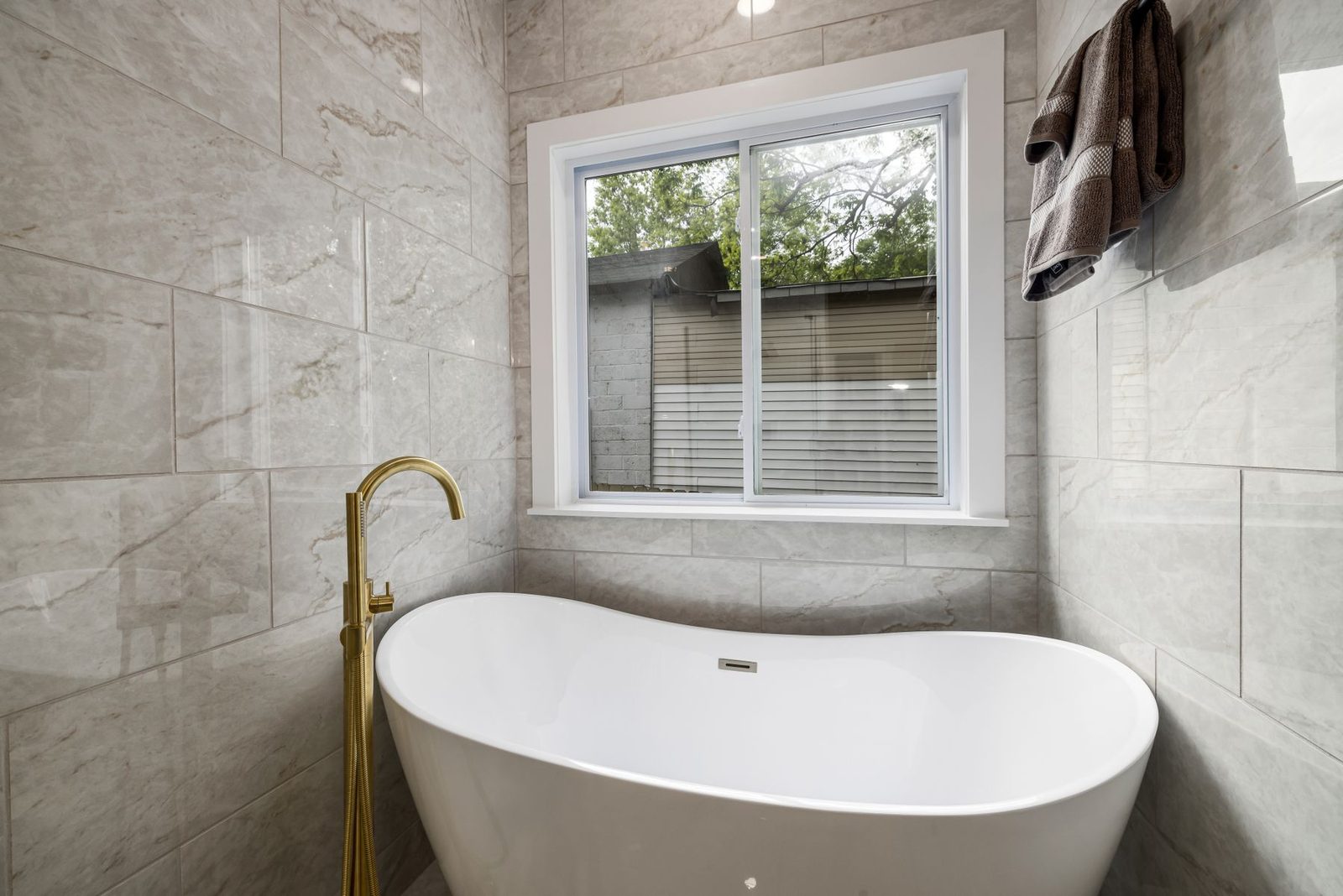Marble bathroom with freestanding tub and window