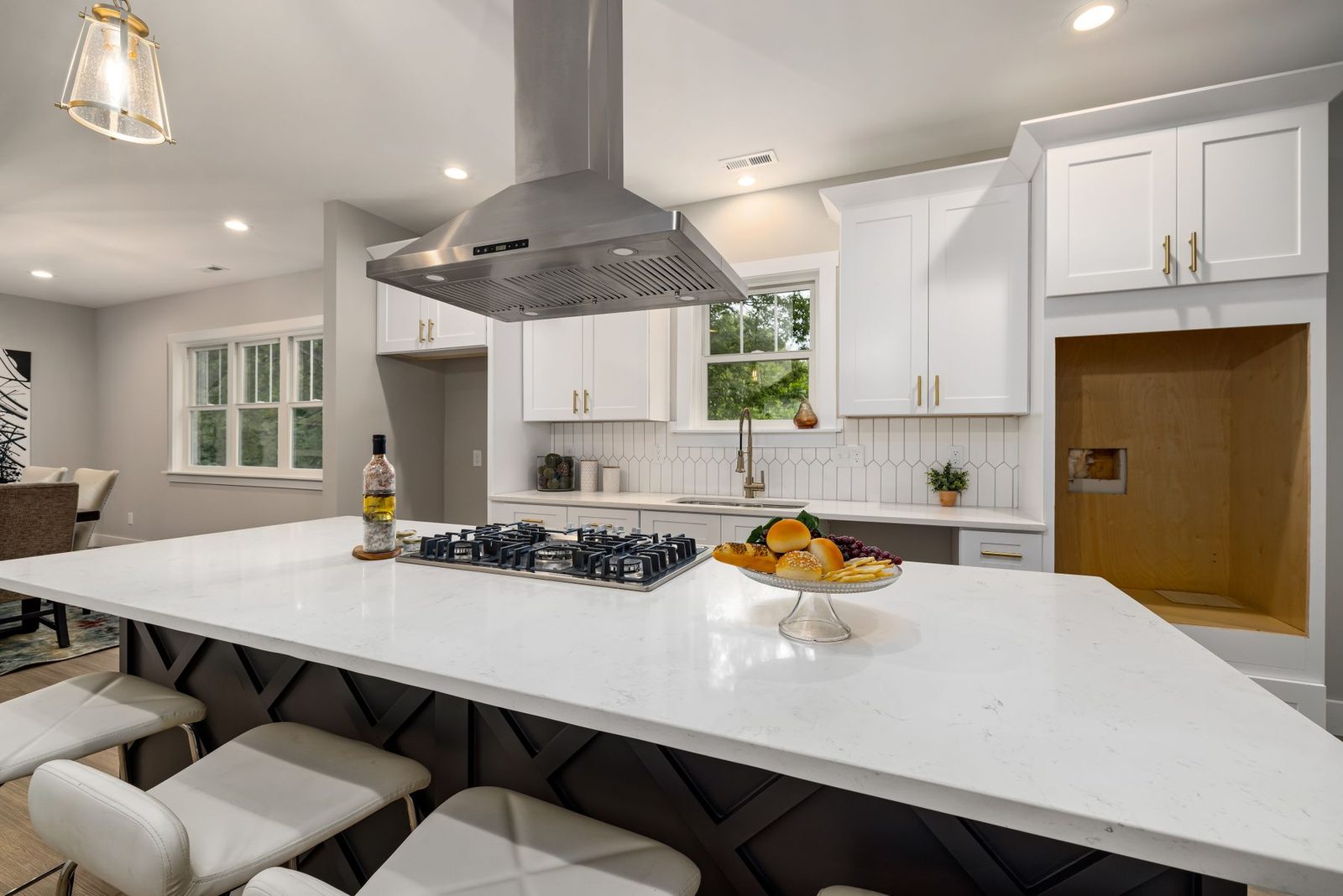 Modern kitchen with white cabinets, island and range hood