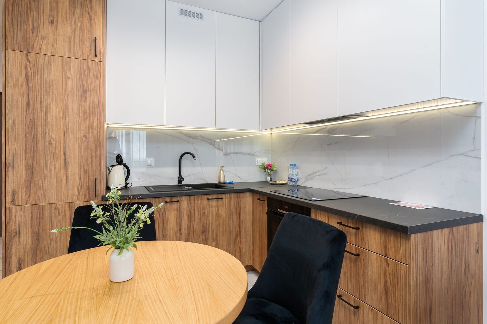 Modern kitchen with wood cabinetry and white backsplash – cabinets and countertops