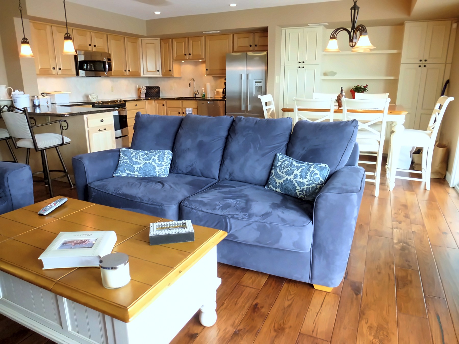 Portfolio photo: Open kitchen and living room with blue sofa and hardwood floors