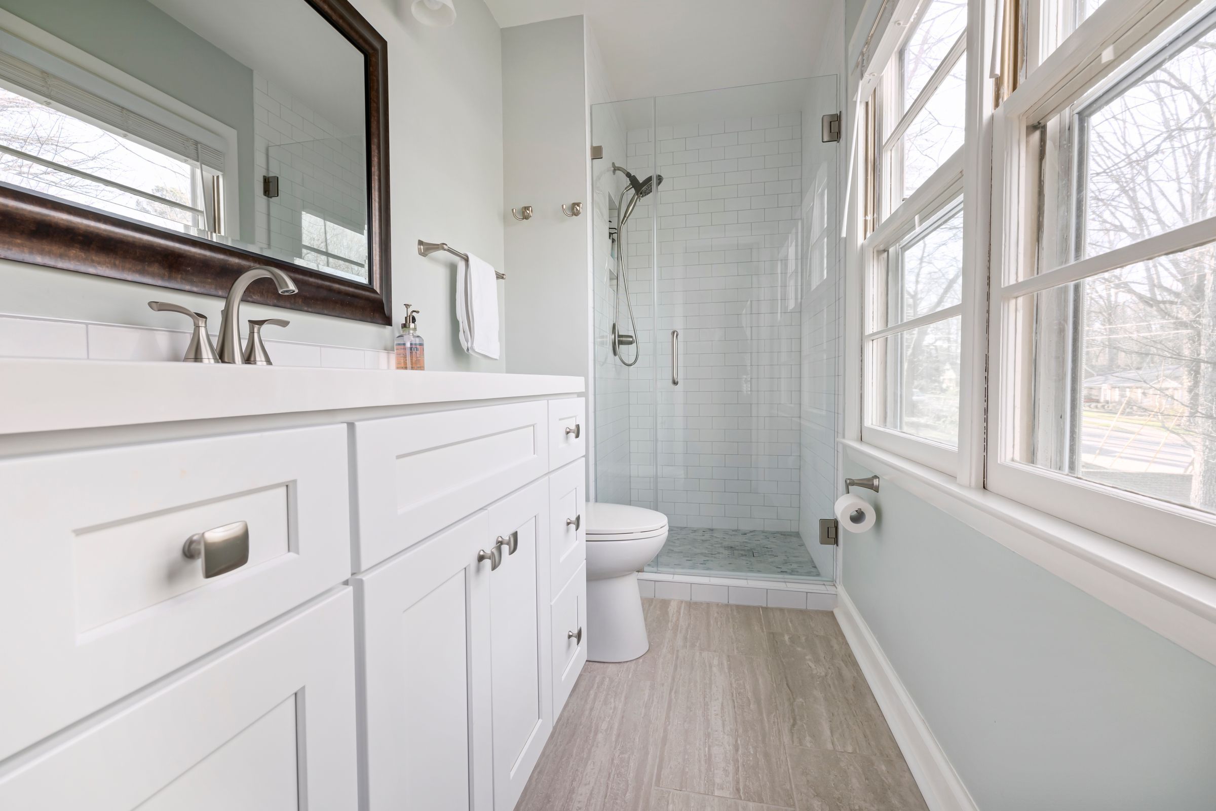 Bright bathroom with white vanity and glass walk-in shower