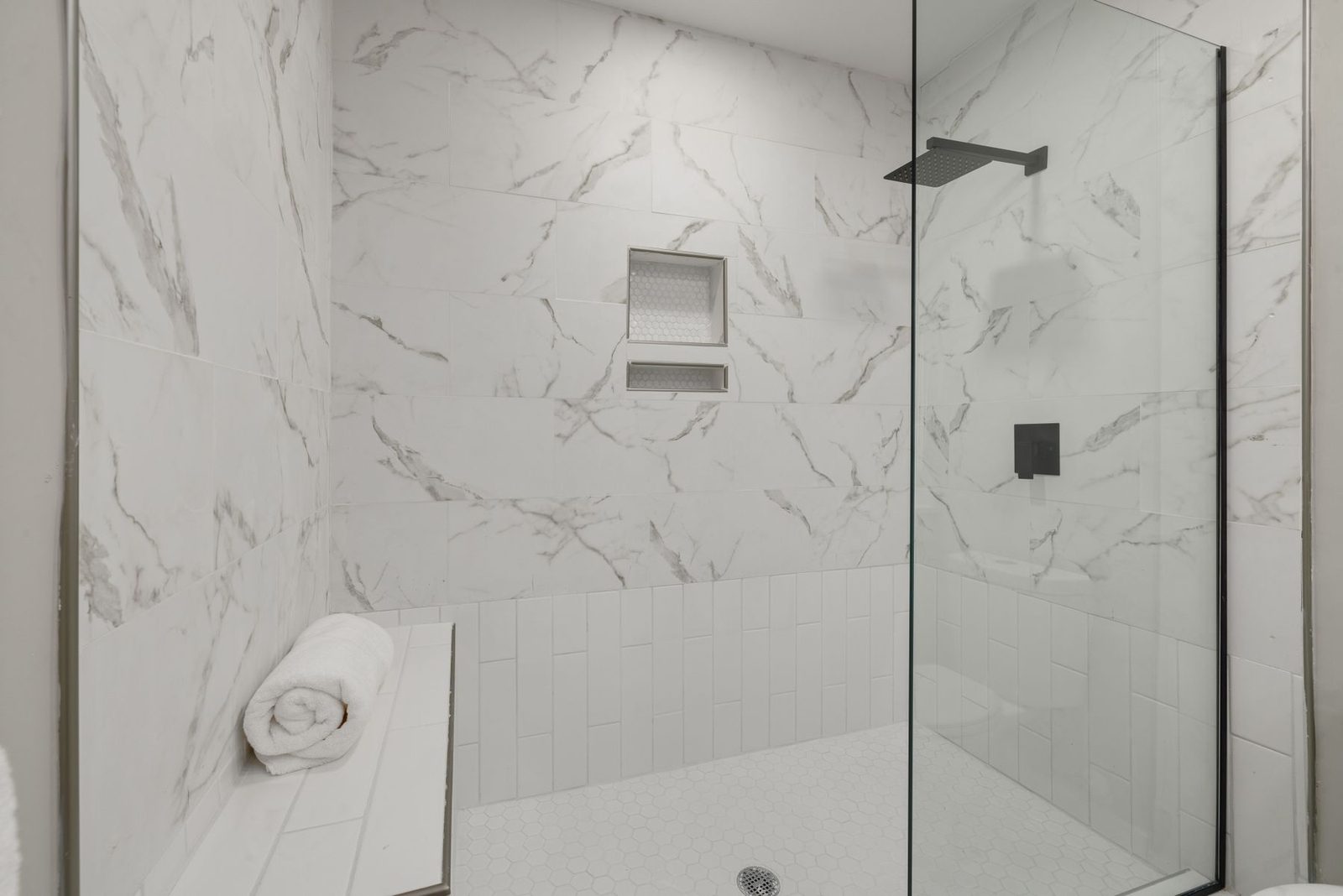 White marble walk-in shower with glass door