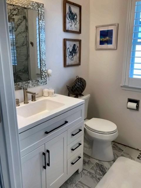 Bathroom with white vanity, black hardware and marble-look tile floor
